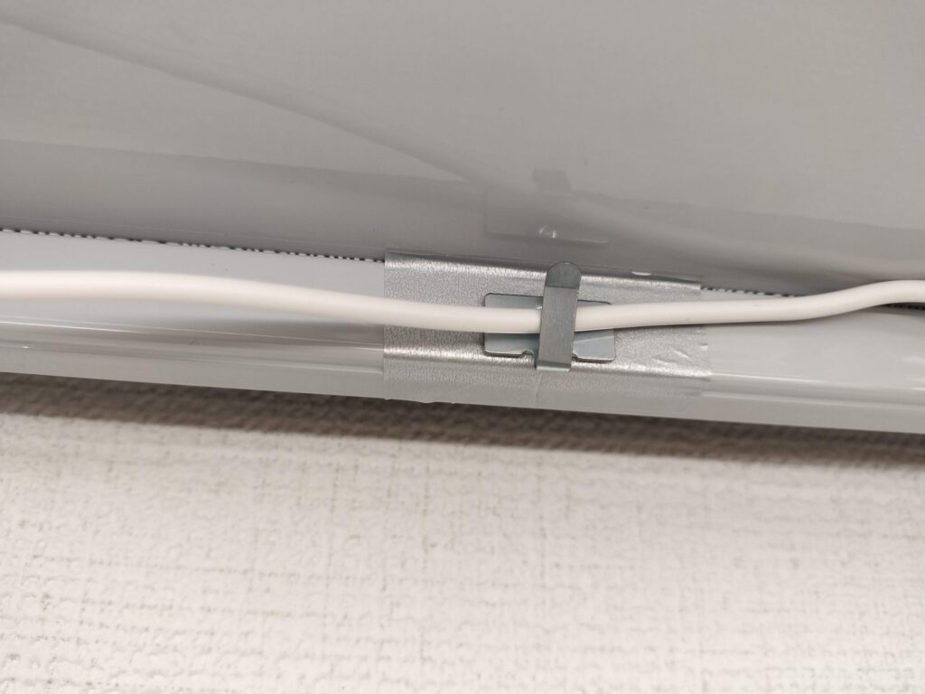 DAISOのコードフックがコードを棚に固定しているアップ写真