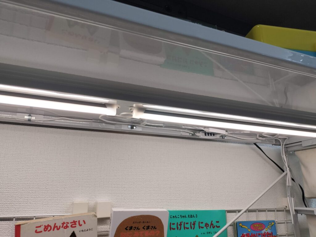 照明がついて完成した絵本棚。LEDライトが棚板を照らし、下に絵本が並んでいる