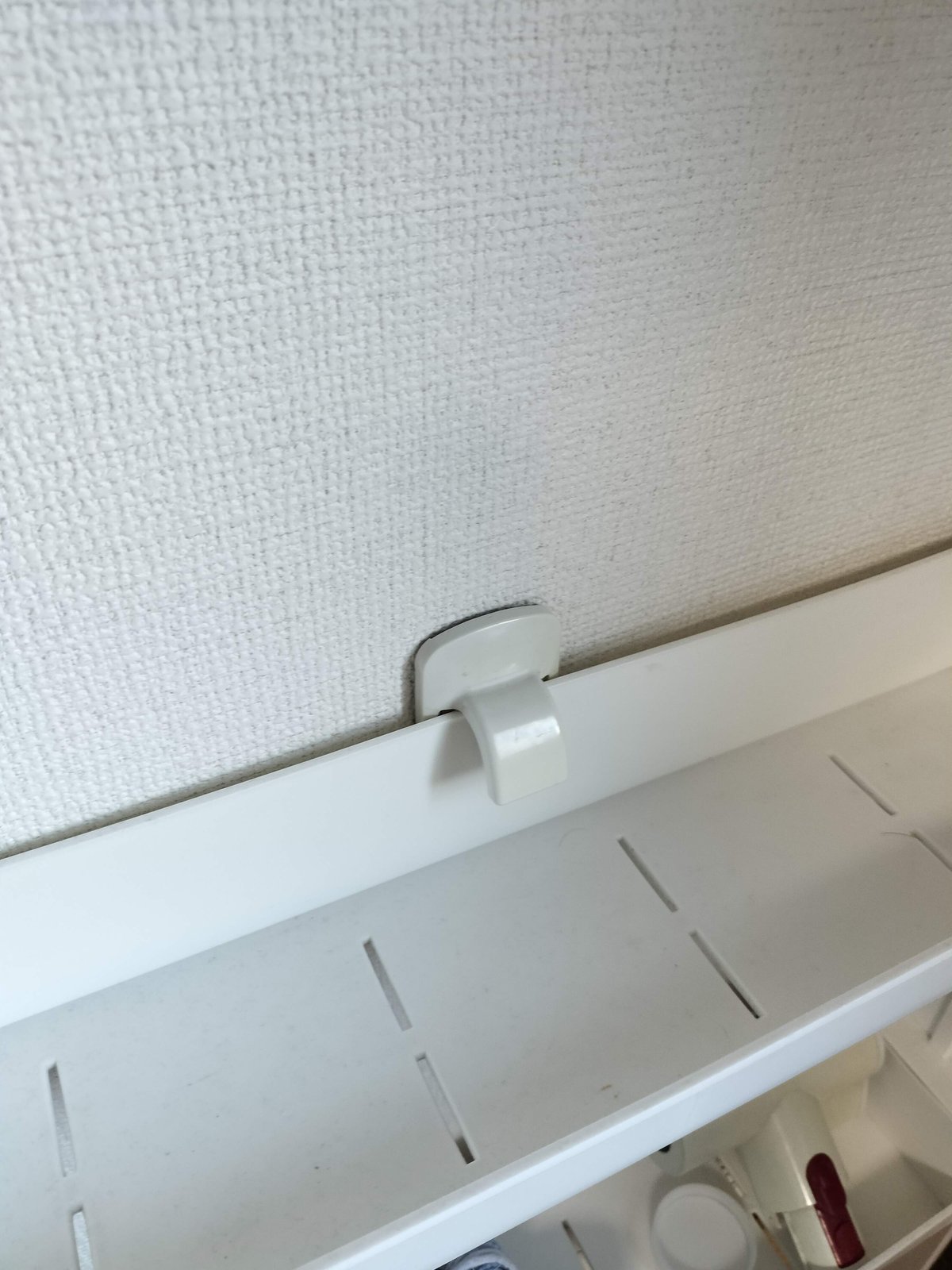 棚の上部にコマンドタブフックを取り付けて転倒防止にした様子