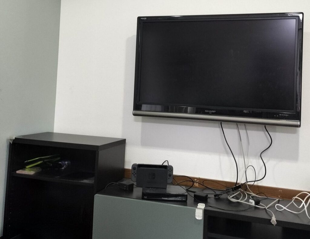 壁掛けテレビの配線がごちゃごちゃと垂れ下がっている様子。