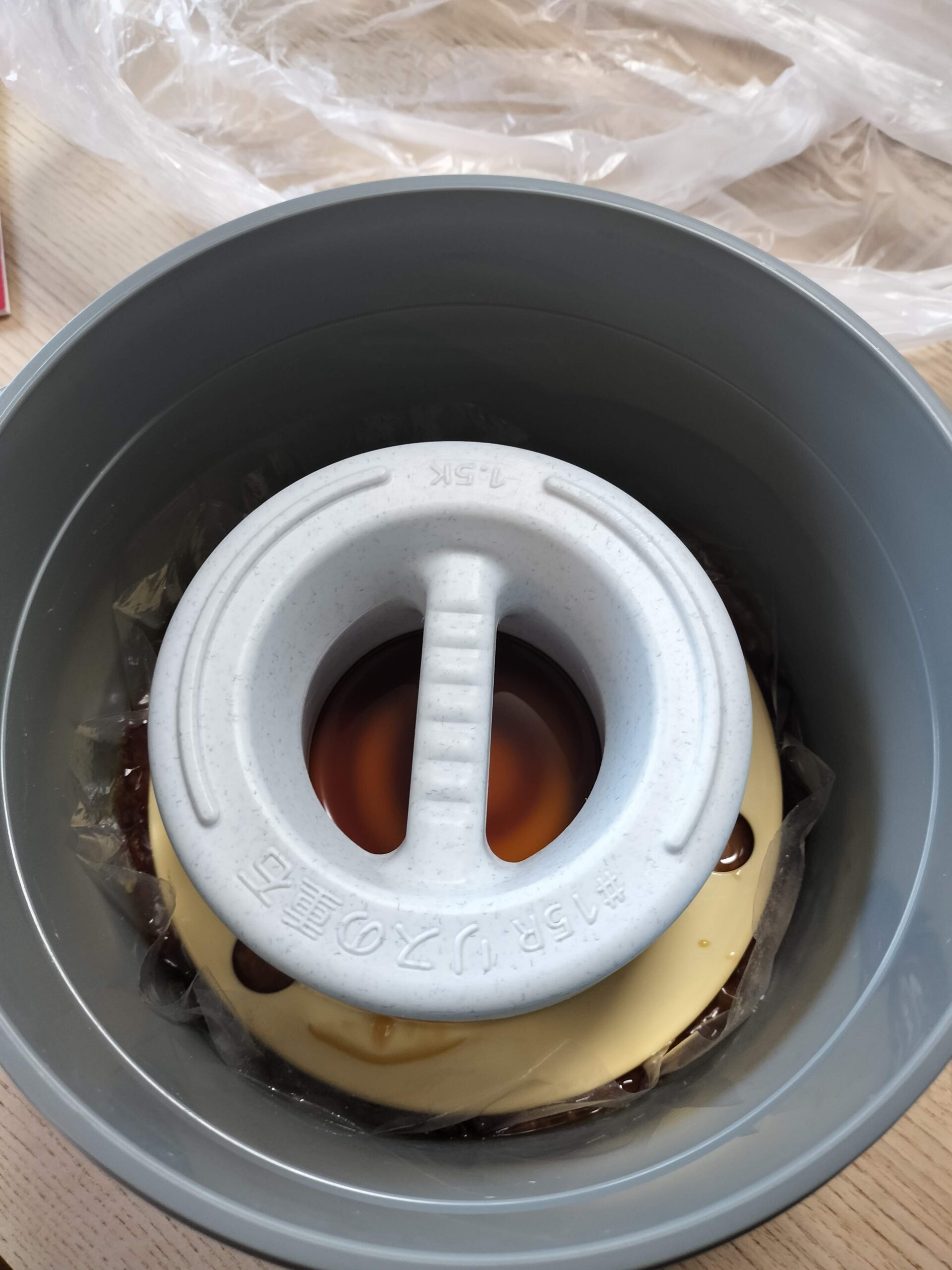 保存容器の蓋を開け、たまりが溜まった味噌を確認する様子
