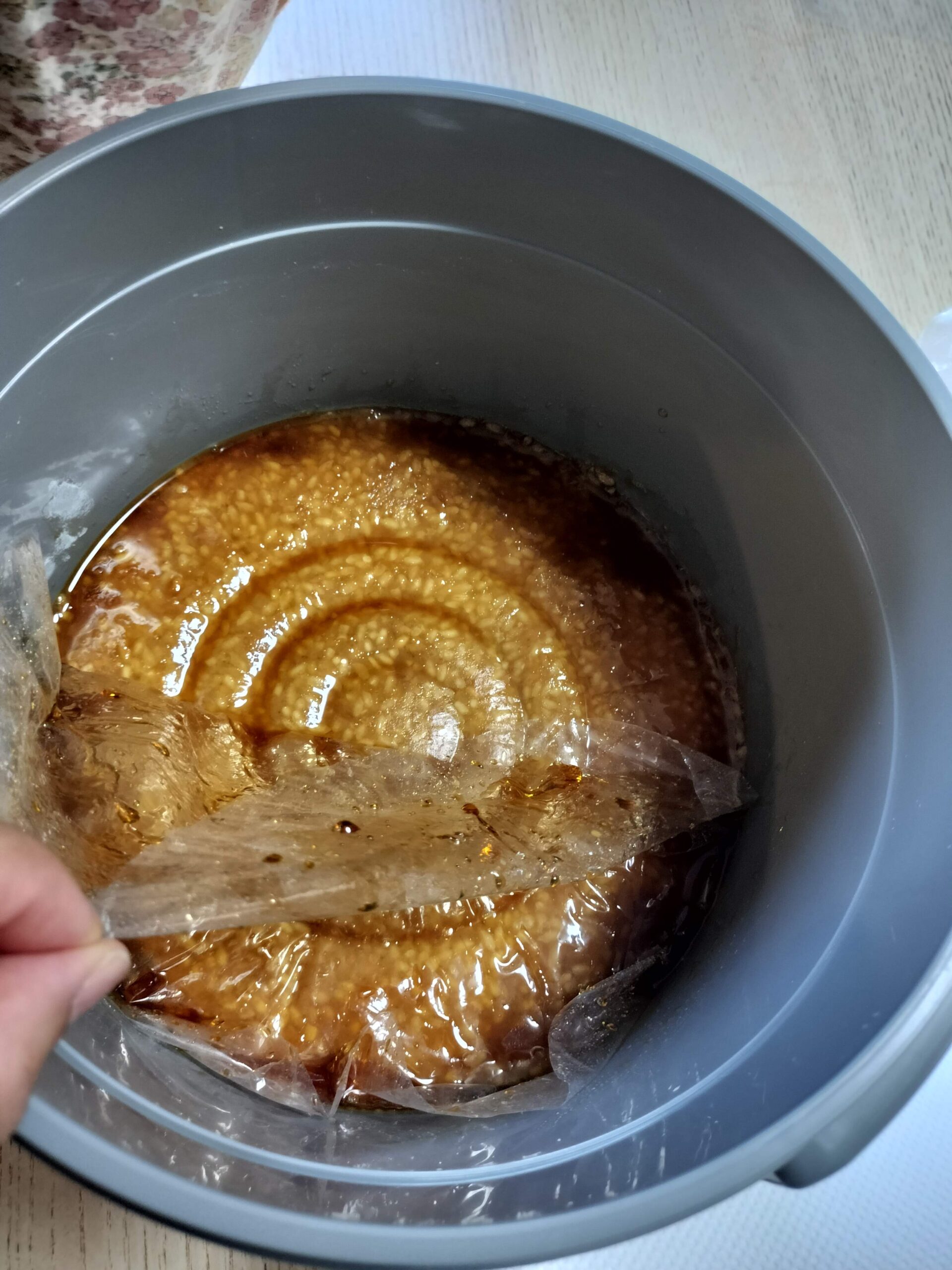 保存容器の蓋を開け、たまりと味噌の間のビニールを取り除く様子
