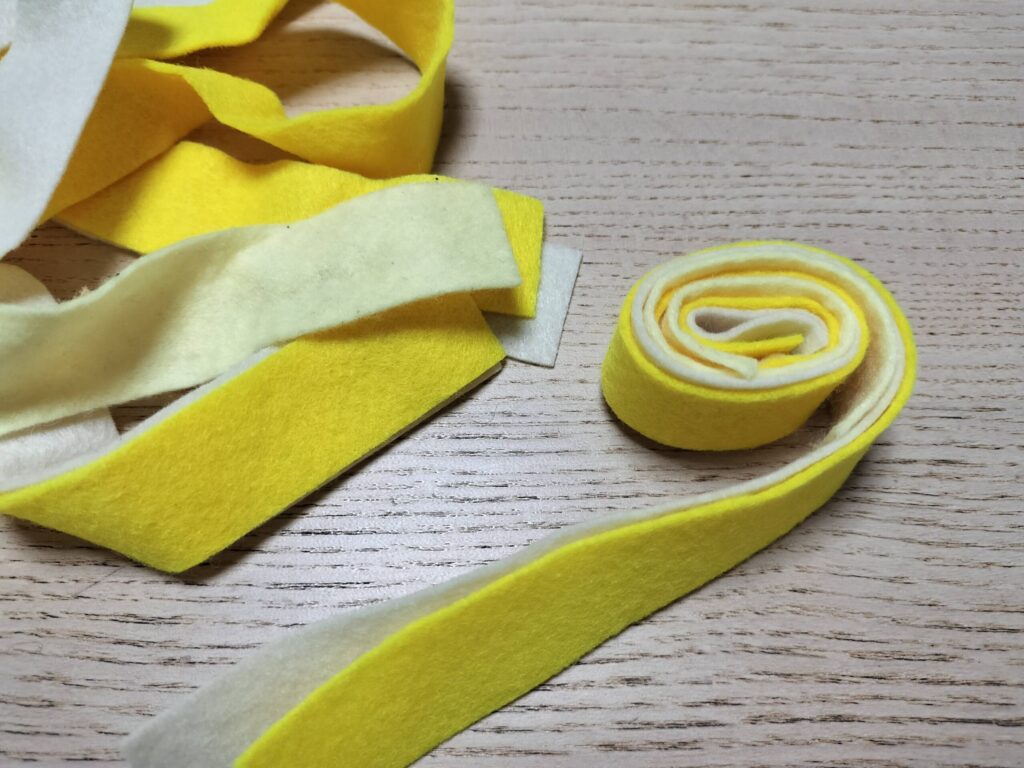 ままごとの食材用に黄色いフェルトのテープを巻いている様子