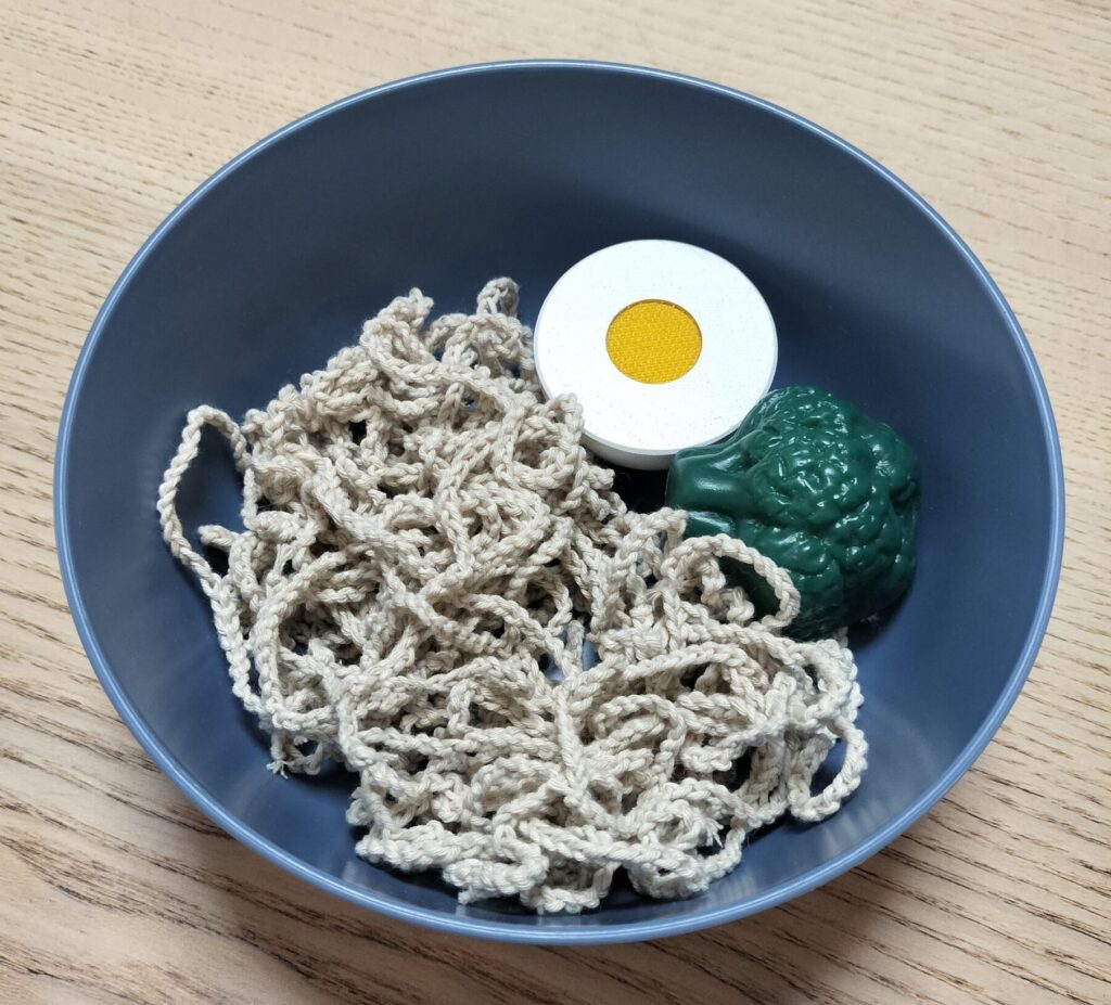 鎖編みの麺と卵・薬味を盛り付けた完成したうどん風のままごと