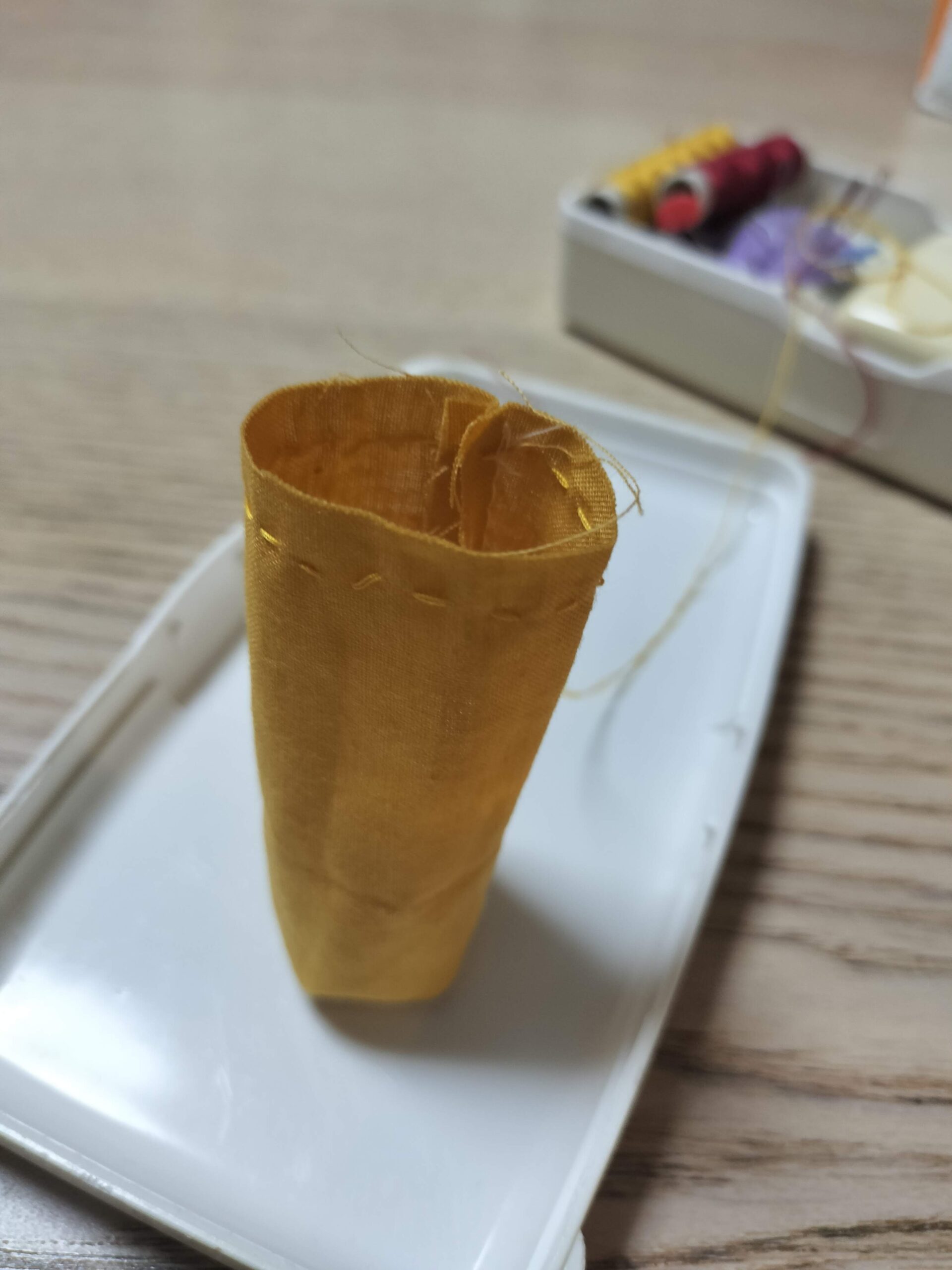 お手玉の片側を並縫いで閉じる様子