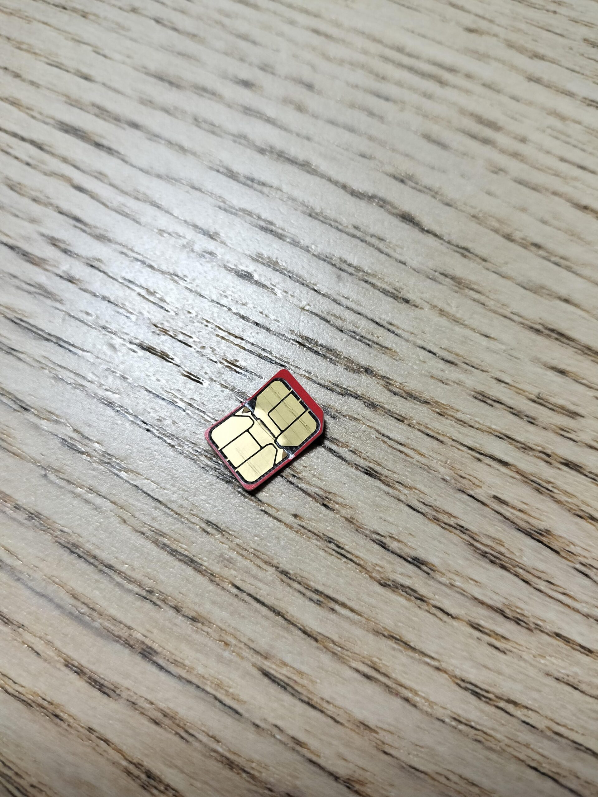 木のテーブルに置いた赤いnano SIMカード